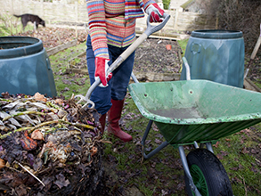 Person building compost in her backyard.